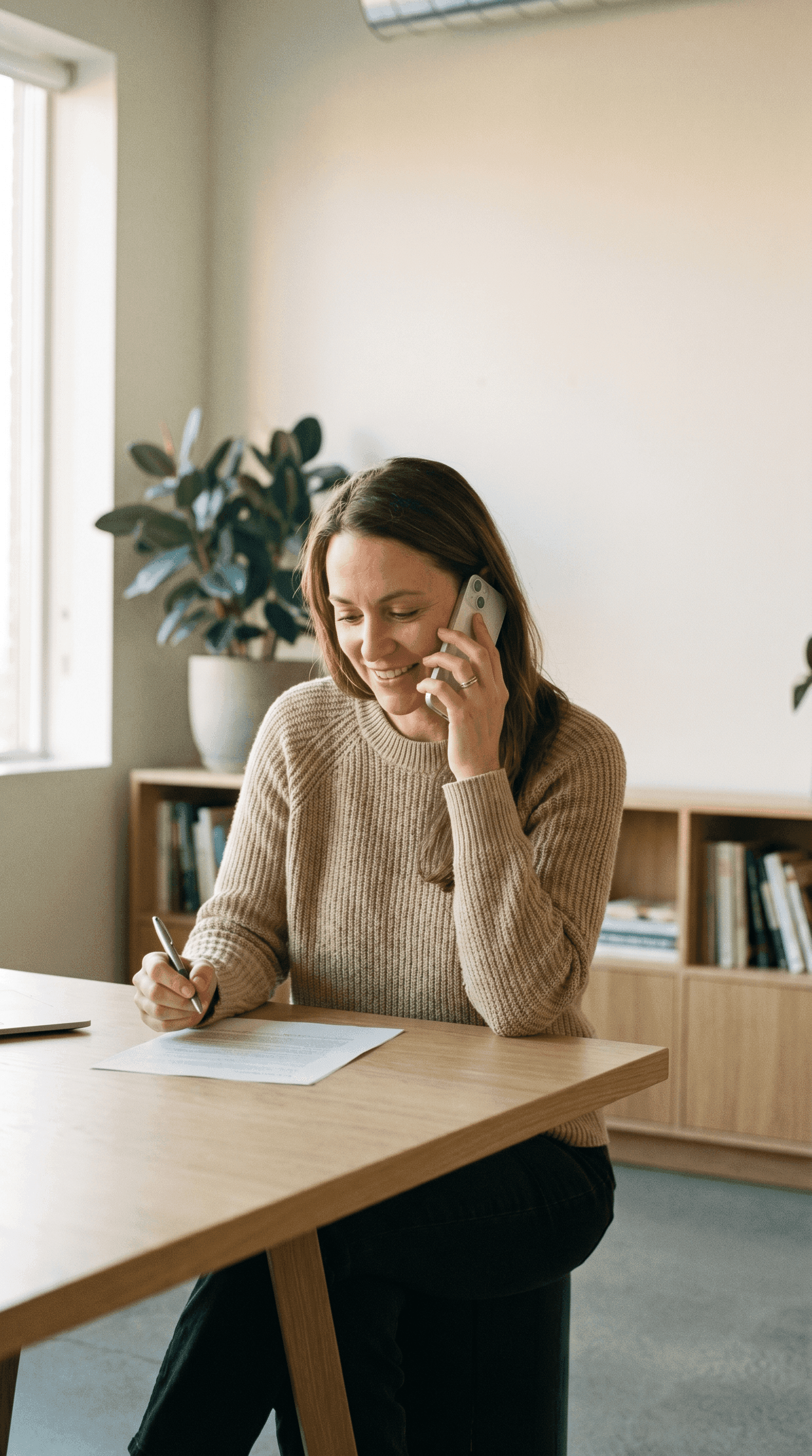 Conseillère Reference Software au téléphone, prenant des notes pendant un échange client